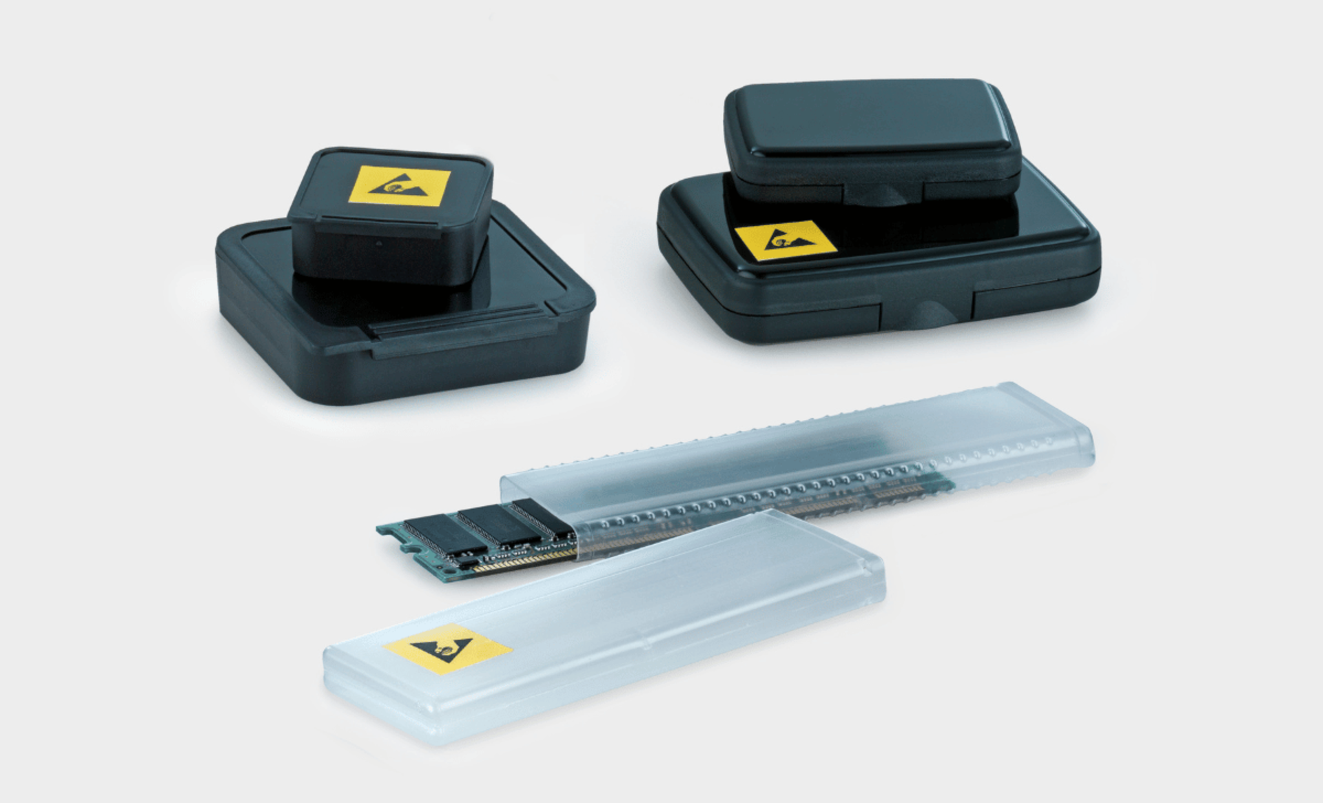 Zwei ESD-Boxen und eine transparente Verpackungshülse mit eingelegtem Speichermodul, alle mit ESD-Warnsymbol versehen