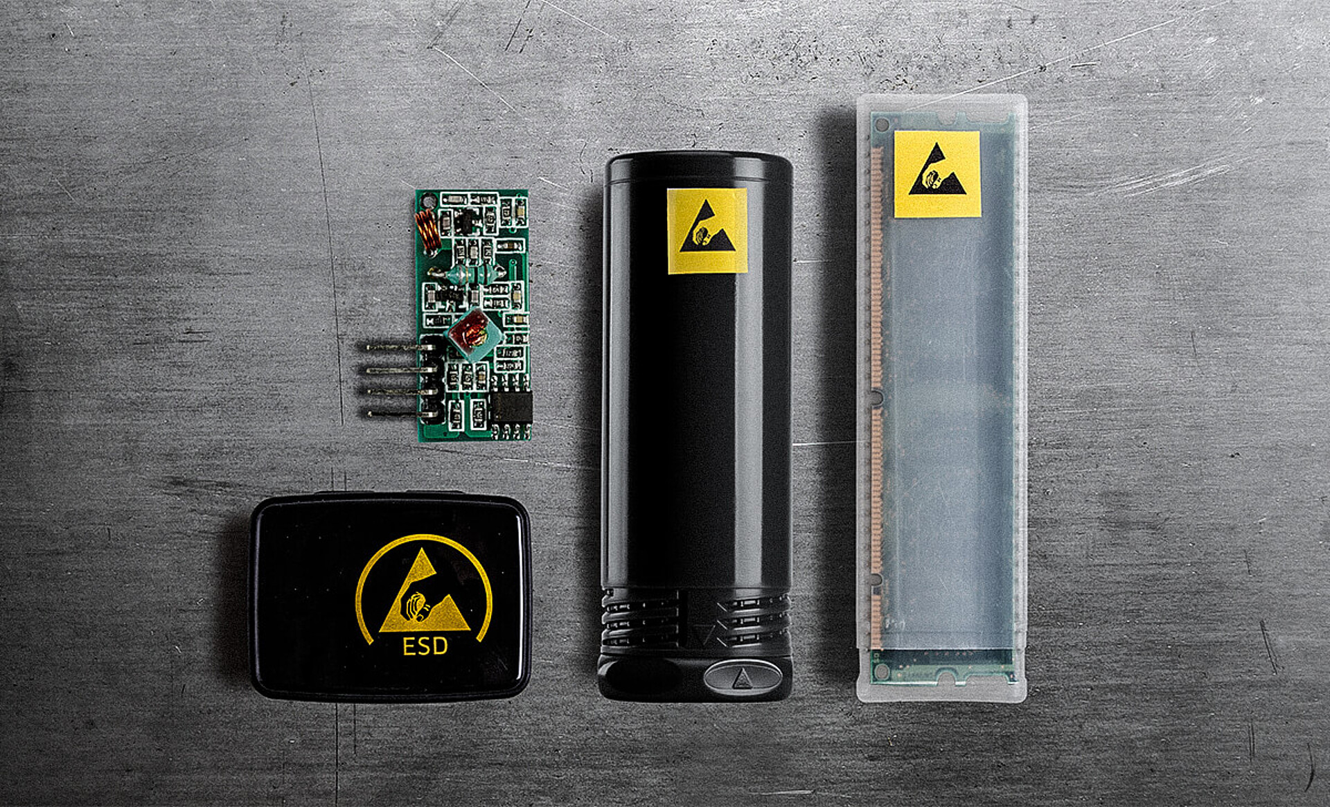 Verschiedene ESD-Schutzverpackungen von rose plastic – Kunststoffhülsen und Boxen – jeweils mit ESD-Warnsymbol gekennzeichnet, daneben eine ungeschützte Elektronik-Platine zur Veranschaulichung des Schutzbedarfs